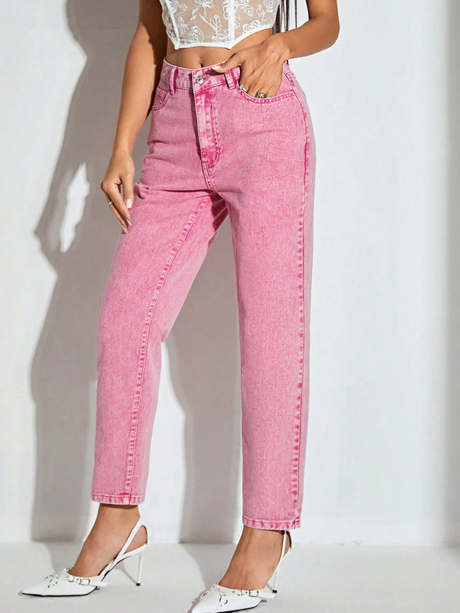 Person wearing pink jeans and white shoes on a plain background