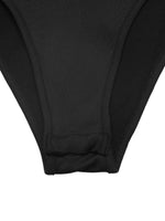 Close-up of black pants with a white background