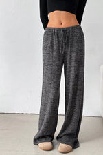 Person wearing gray checkered pants with a white background