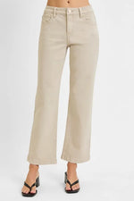 Beige wide-leg jeans worn by a person on a white background