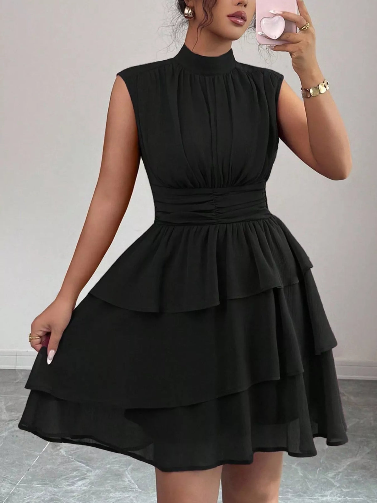 Black dress worn by a person against a neutral background