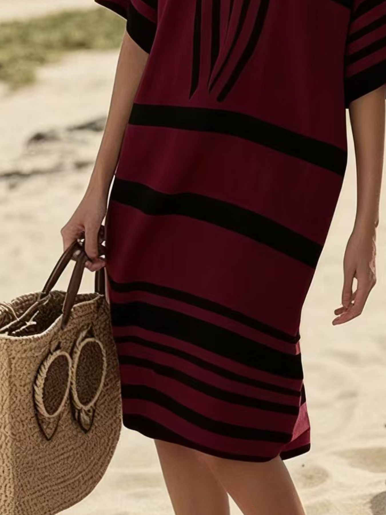 Close up of the bottom of the burgundy and black striped dress
