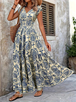 Woman wearing a floral dress standing against a stone wall.