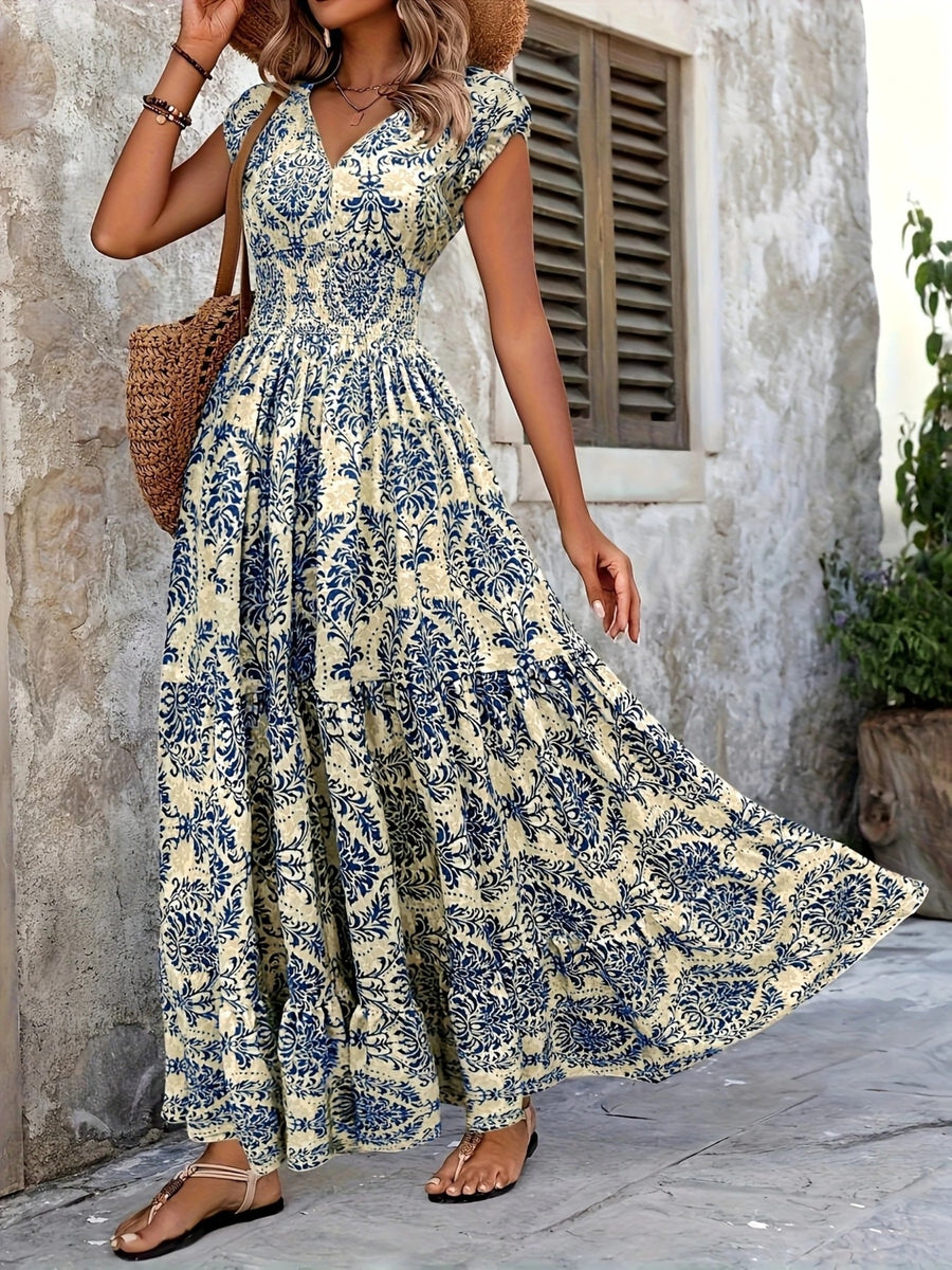Woman wearing a floral dress standing against a stone wall.