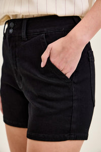 
Woman with her hand in her pocket wearing black shorts