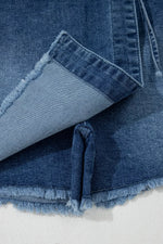Close-up of blue denim fabric with frayed edges on a white background