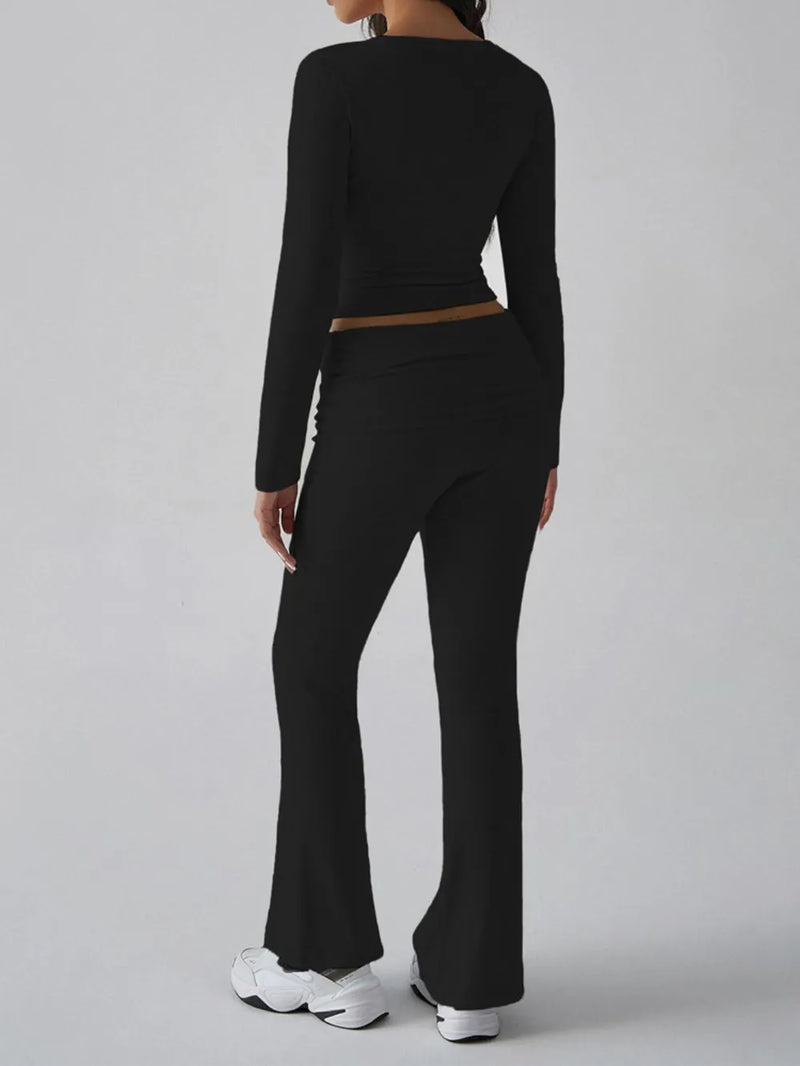 Person wearing a black long-sleeve top and black flared pants on a gray background