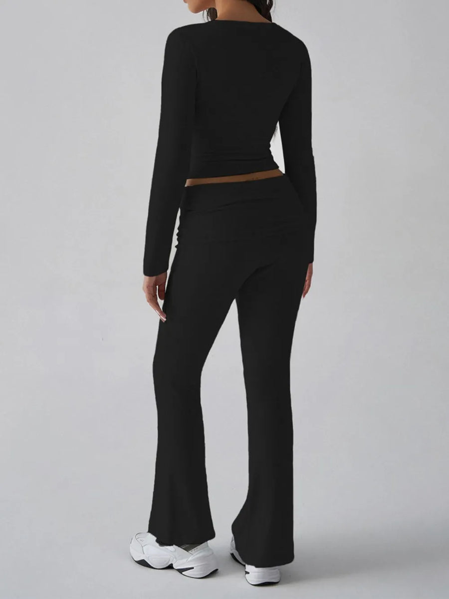 Person wearing a black long-sleeve top and black flared pants on a gray background