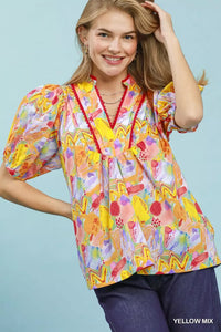 Woman wearing a colorful blouse with a blue background