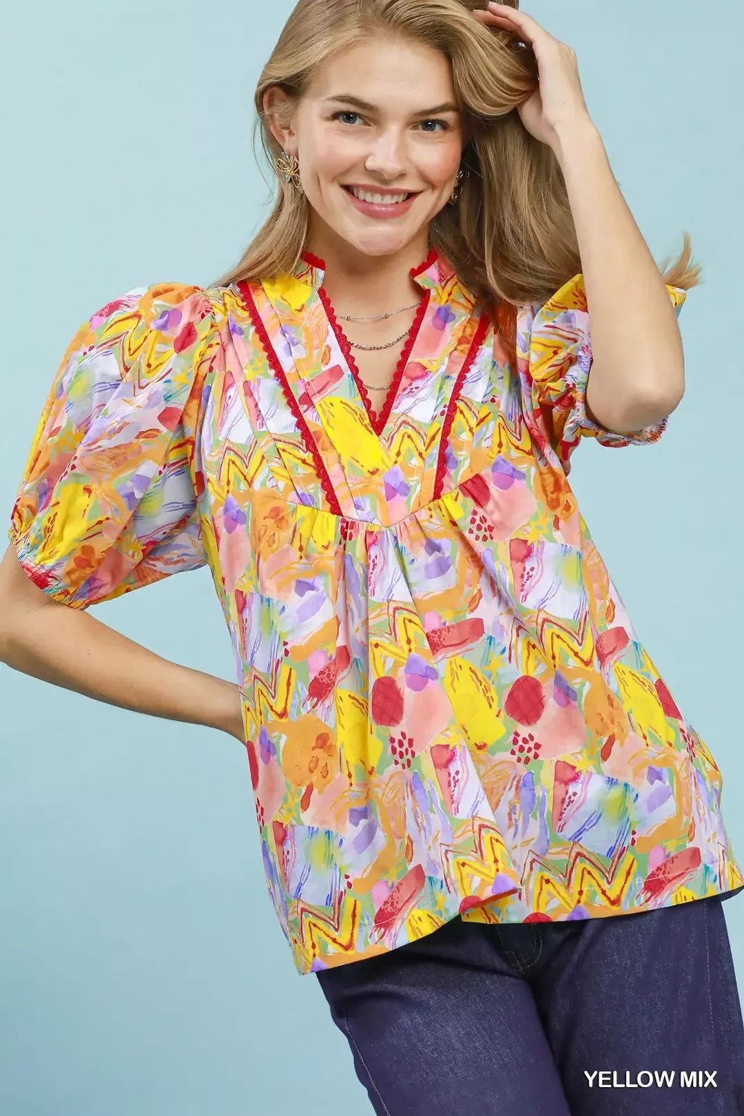 Woman wearing a colorful blouse with a blue background