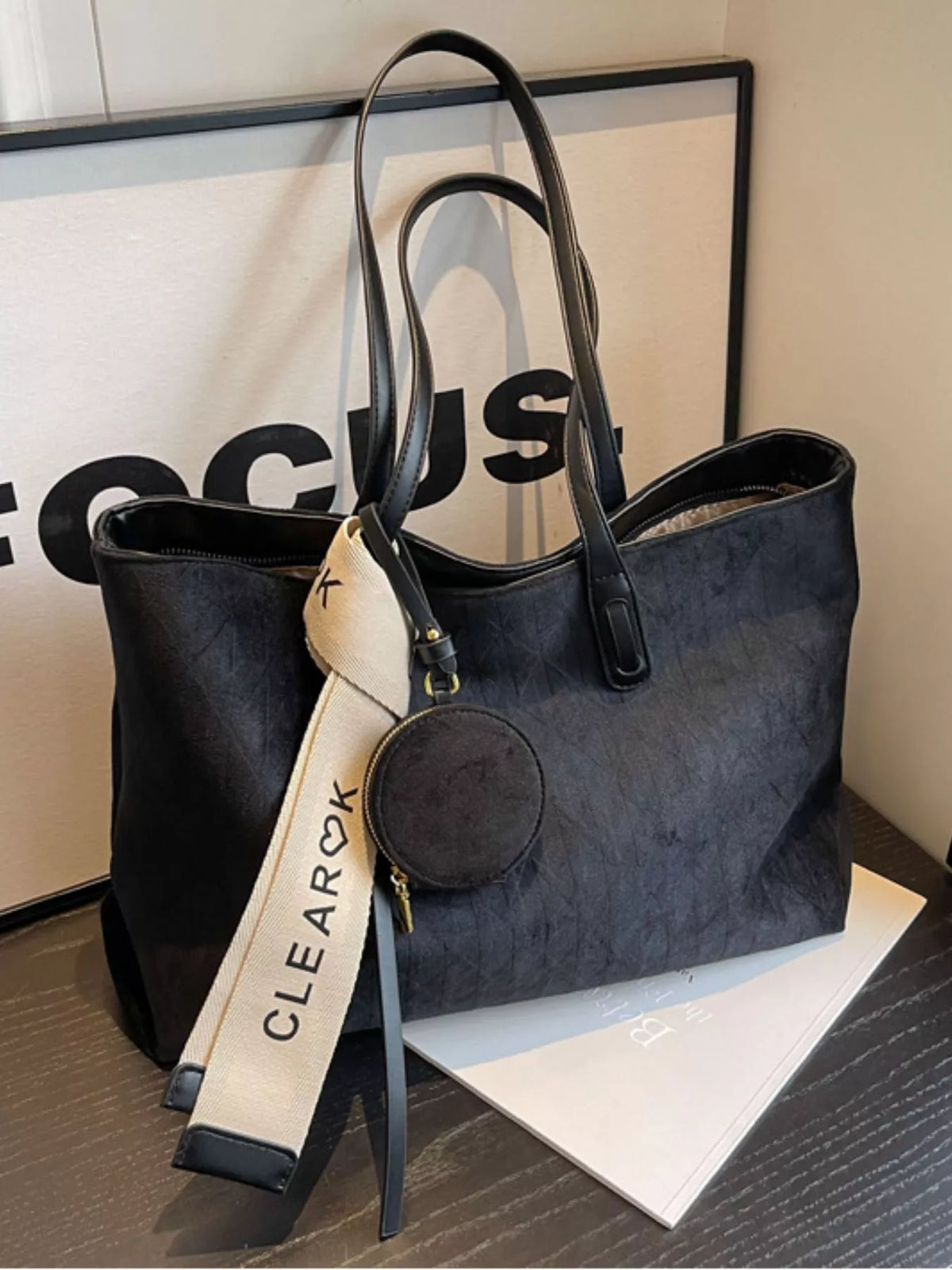 Black handbag with a visible brand tag on a surface