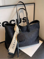 Black handbag with a visible brand tag on a surface
