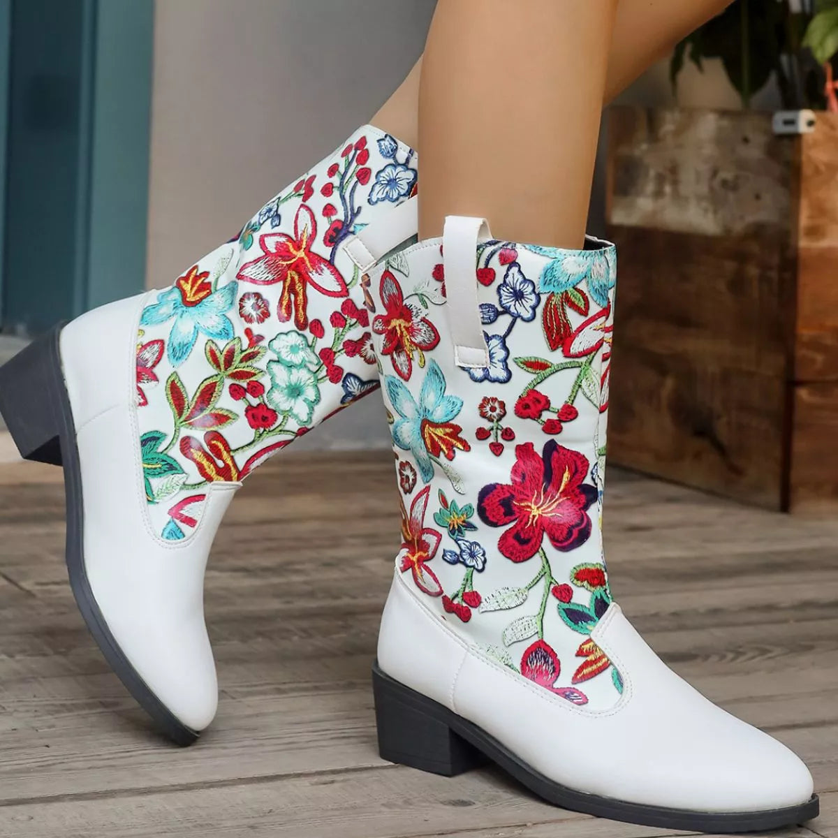 White boots with colorful floral pattern on a wooden floor