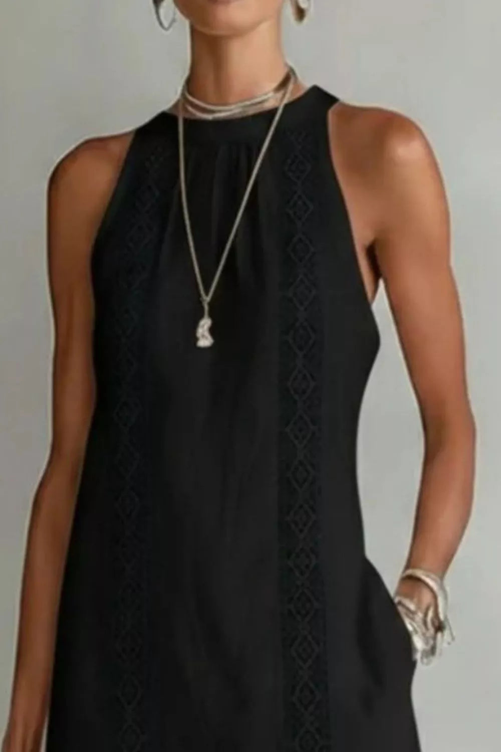 Black dress with intricate detailing on a plain background