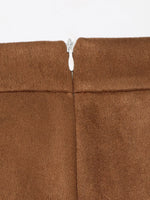 Close-up of a brown fabric with a zipper running through it on a white background