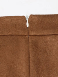 Close-up of a brown fabric with a zipper running through it on a white background