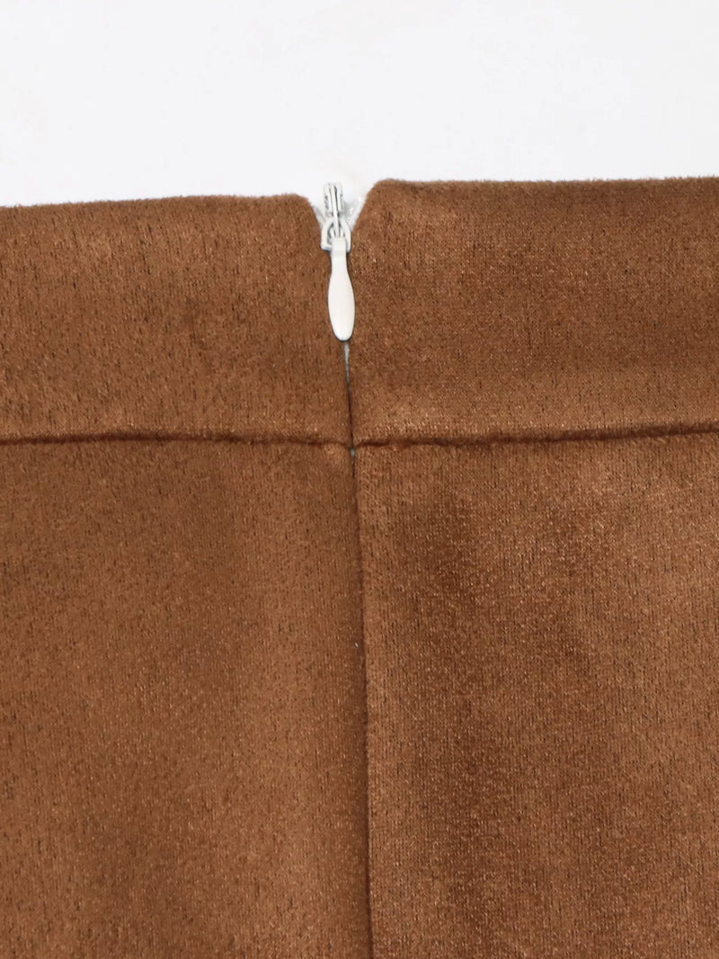 Close-up of a brown fabric with a zipper running through it on a white background