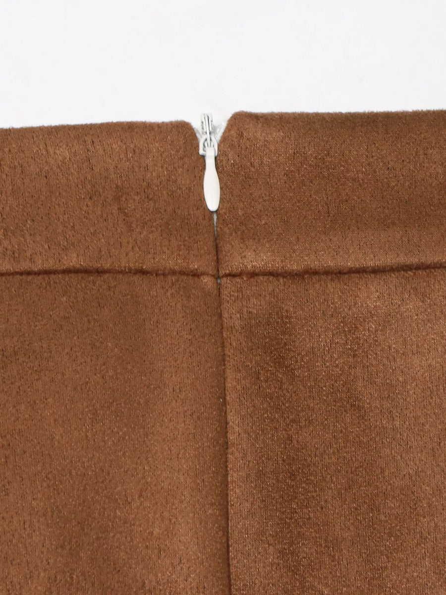 Close-up of a brown fabric with a zipper running through it on a white background