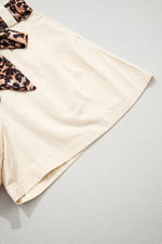 Beige shorts with leopard print accents on a light gray background