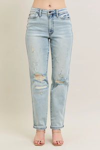 Light blue distressed jeans on a beige background