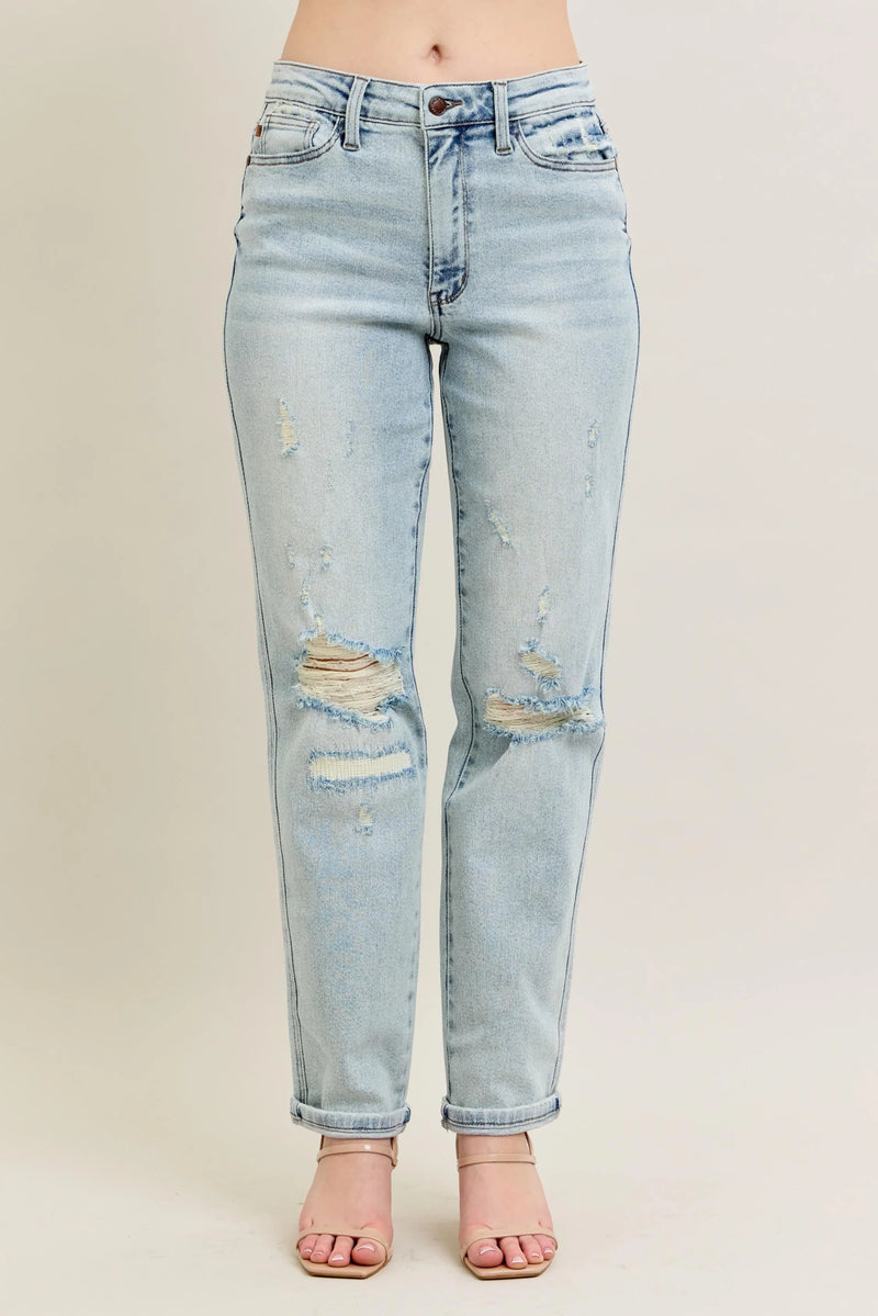 Light blue distressed jeans on a beige background