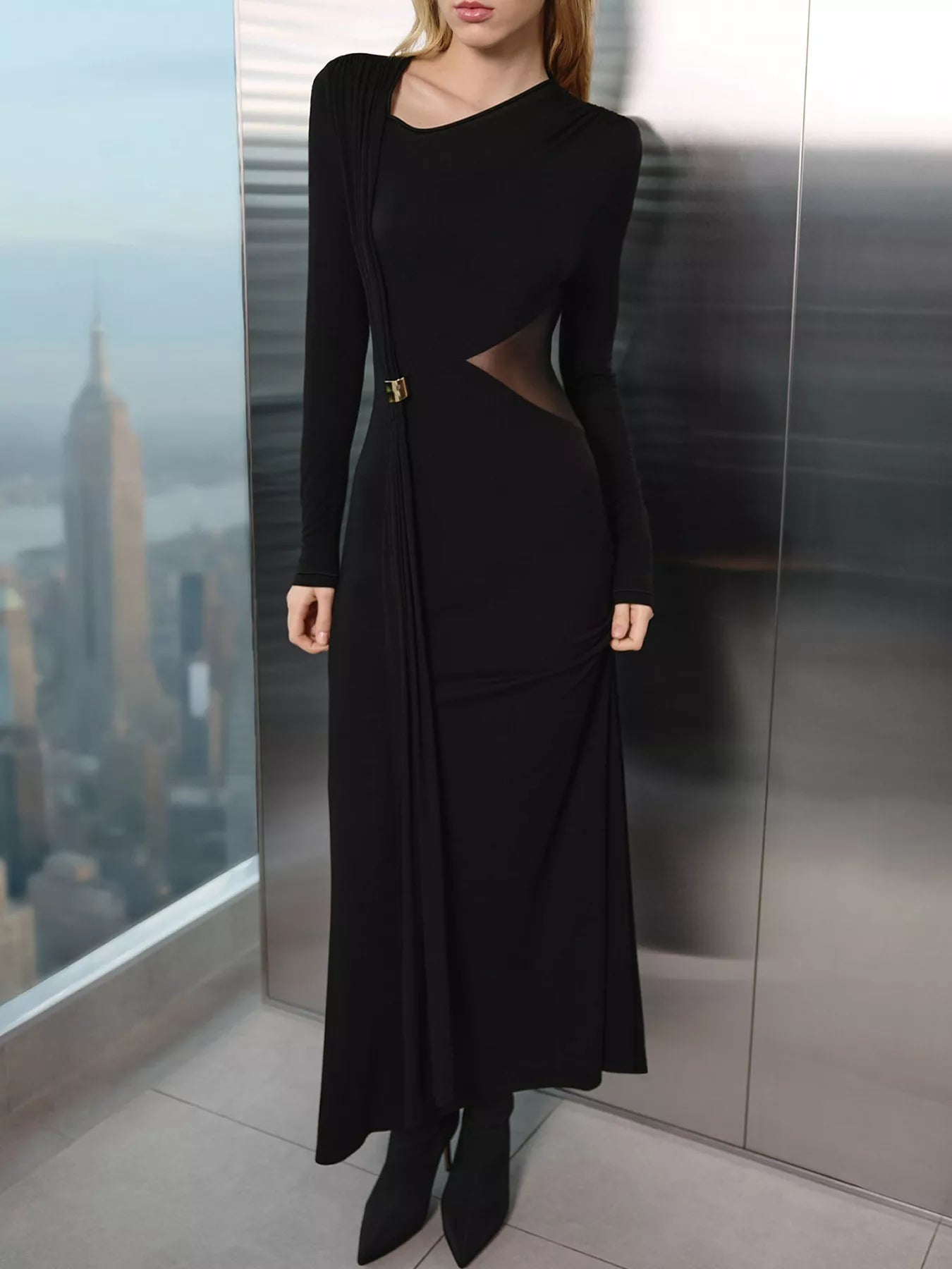 Woman wearing a black dress with cut-out design in an urban setting