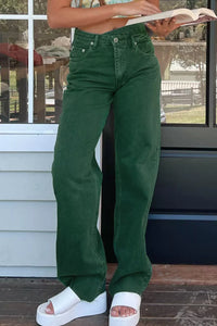 Person wearing green pants and white sandals standing on a wooden deck.