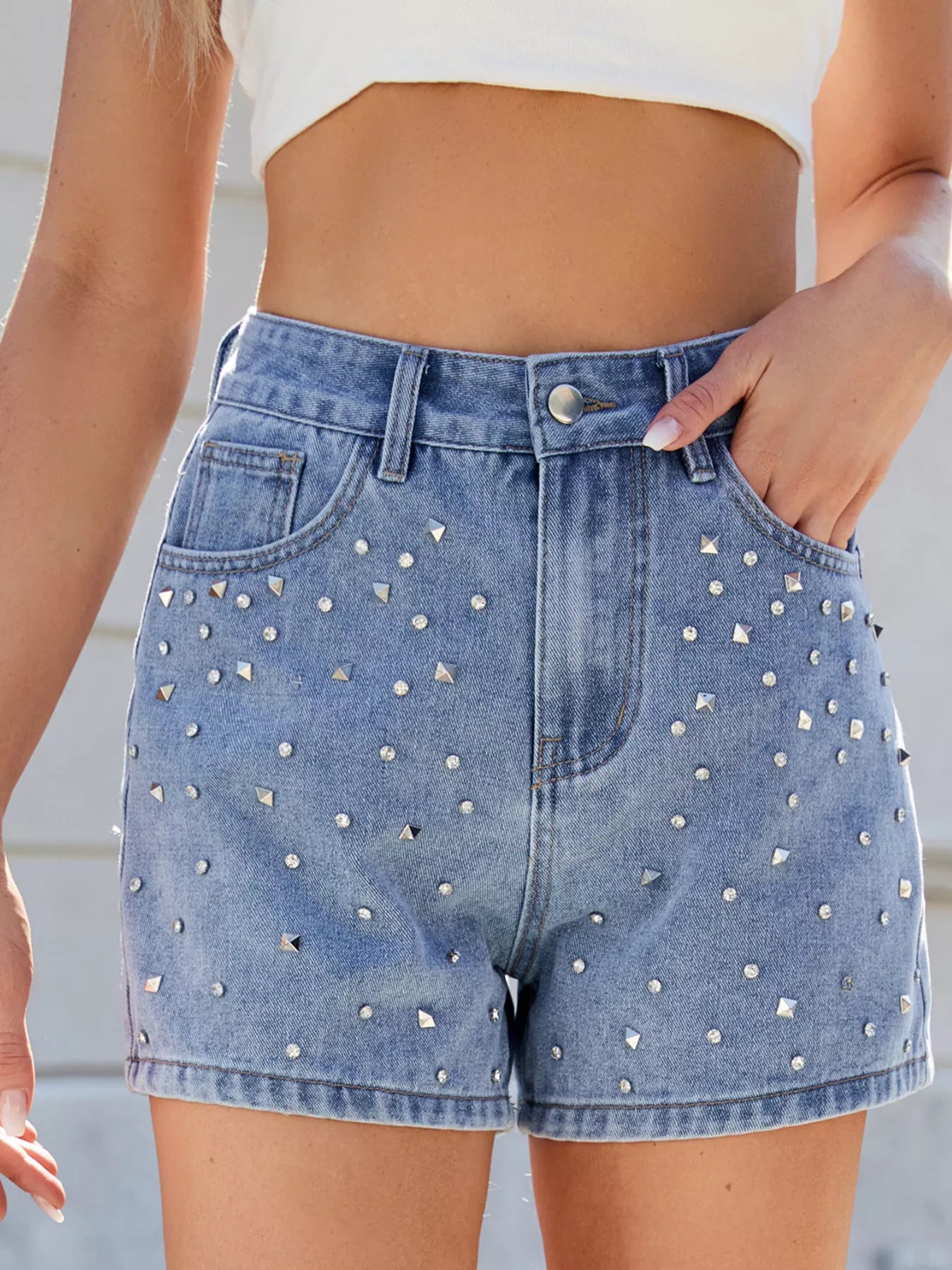 Denim shorts with rhinestone embellishments worn by a person.