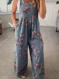 Person wearing a floral denim jumpsuit in a room with a window and rug.