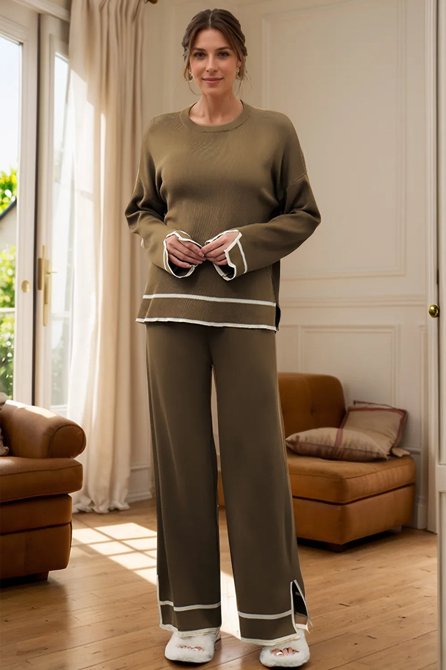 Woman wearing a green outfit standing in a room with brown furniture.