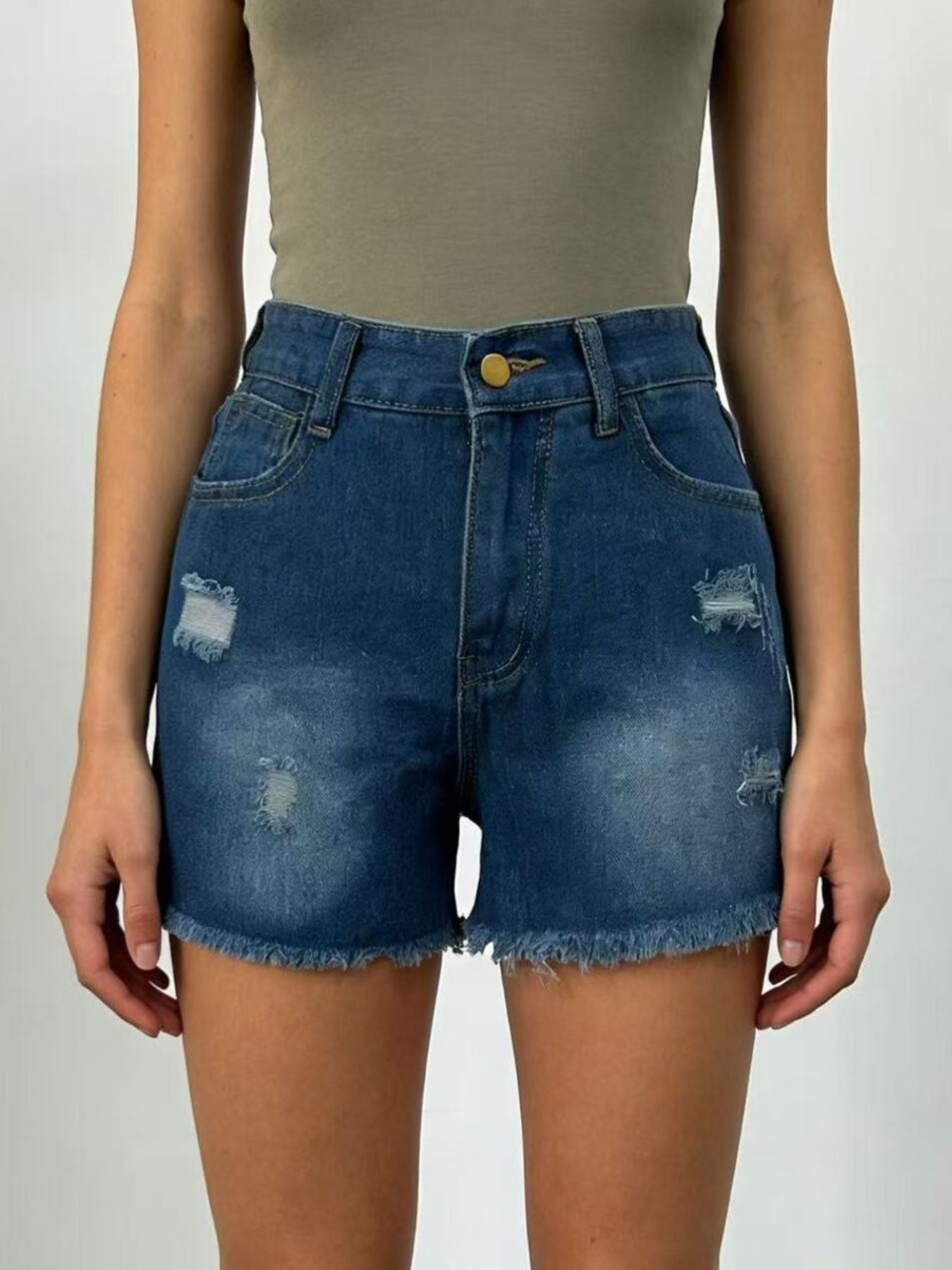 Person wearing blue denim shorts on a plain background