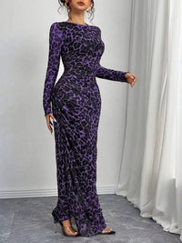 Woman wearing a purple leopard print dress against a white curtain background