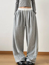 Gray sweatpants with white drawstring on a plain background