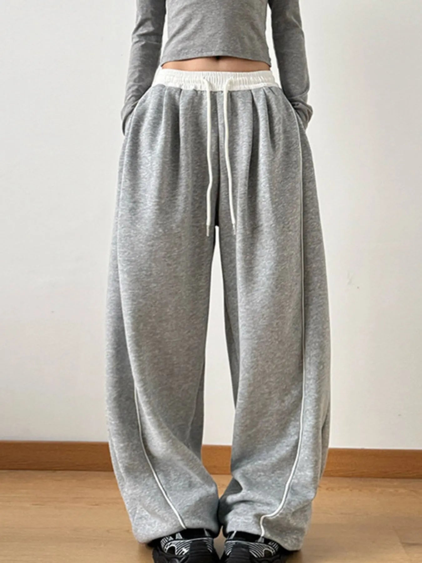 Gray sweatpants with white drawstring on a plain background