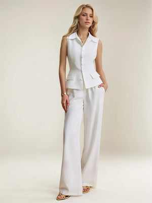 Woman wearing a white sleeveless peplum top and wide-leg pants on a plain background