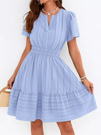 Woman wearing a light blue dress with a white background