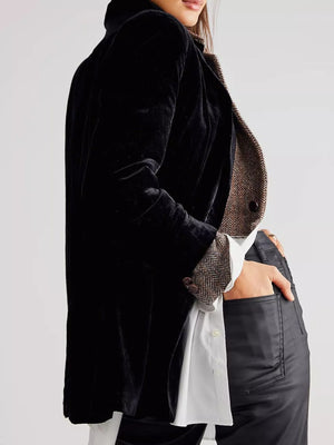 Person wearing a black coat over a plaid shirt with a plain background