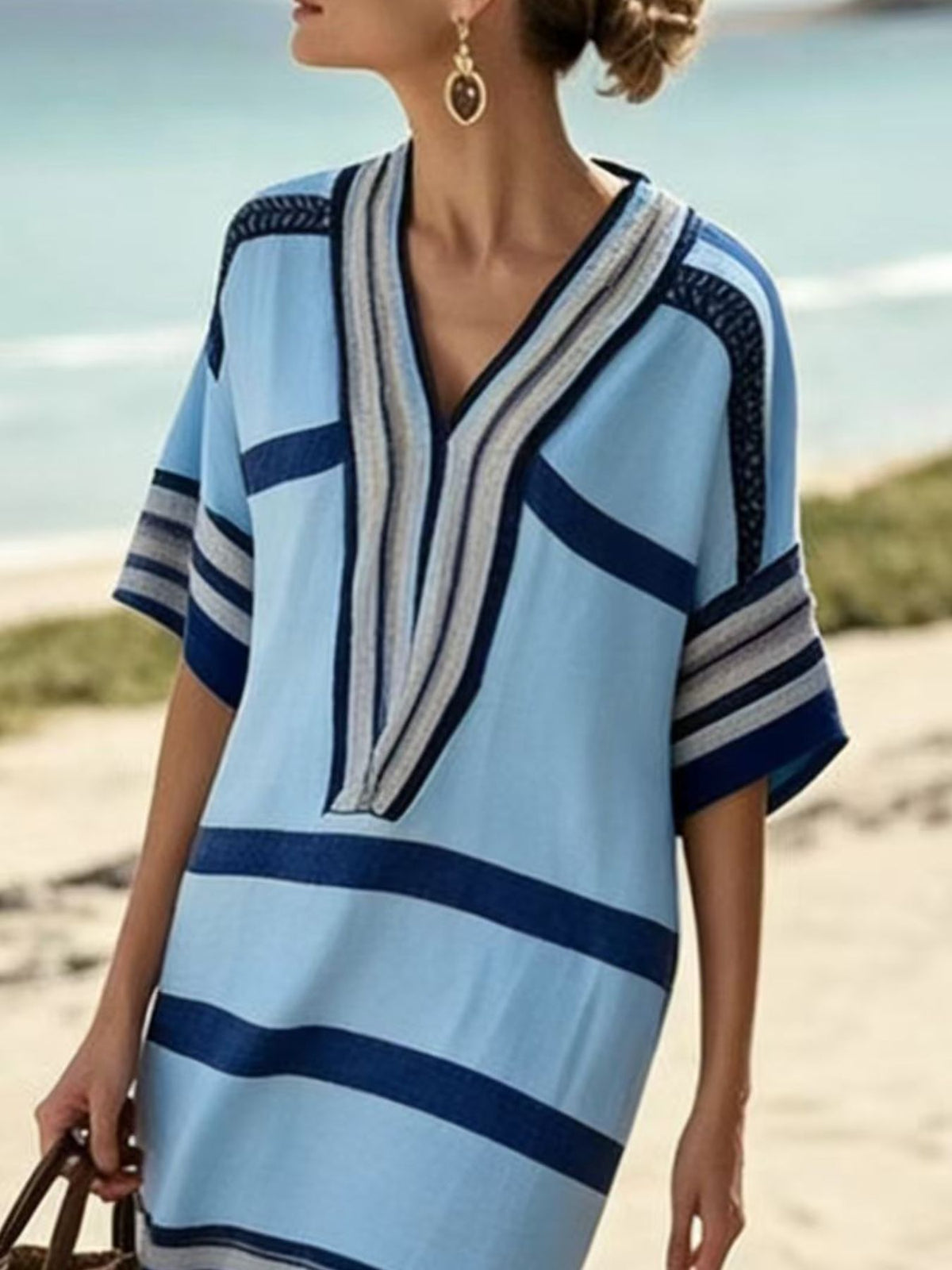 Woman wearing a blue and white striped dress on a beach