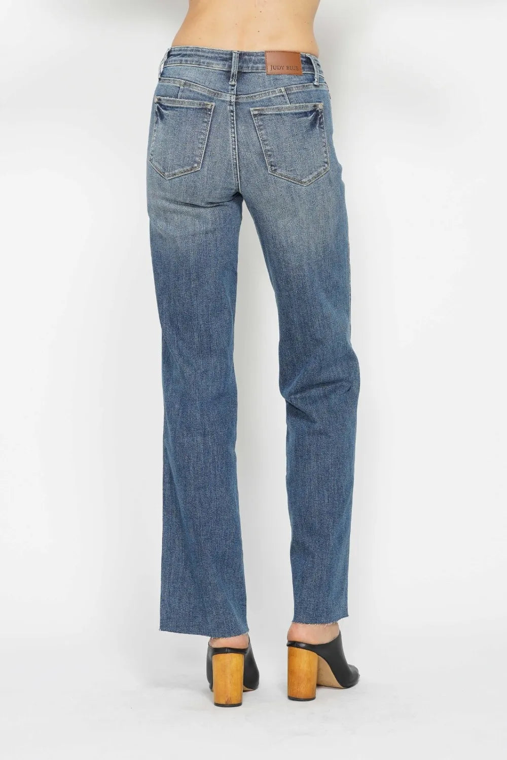 Blue jeans worn by a person on a white background