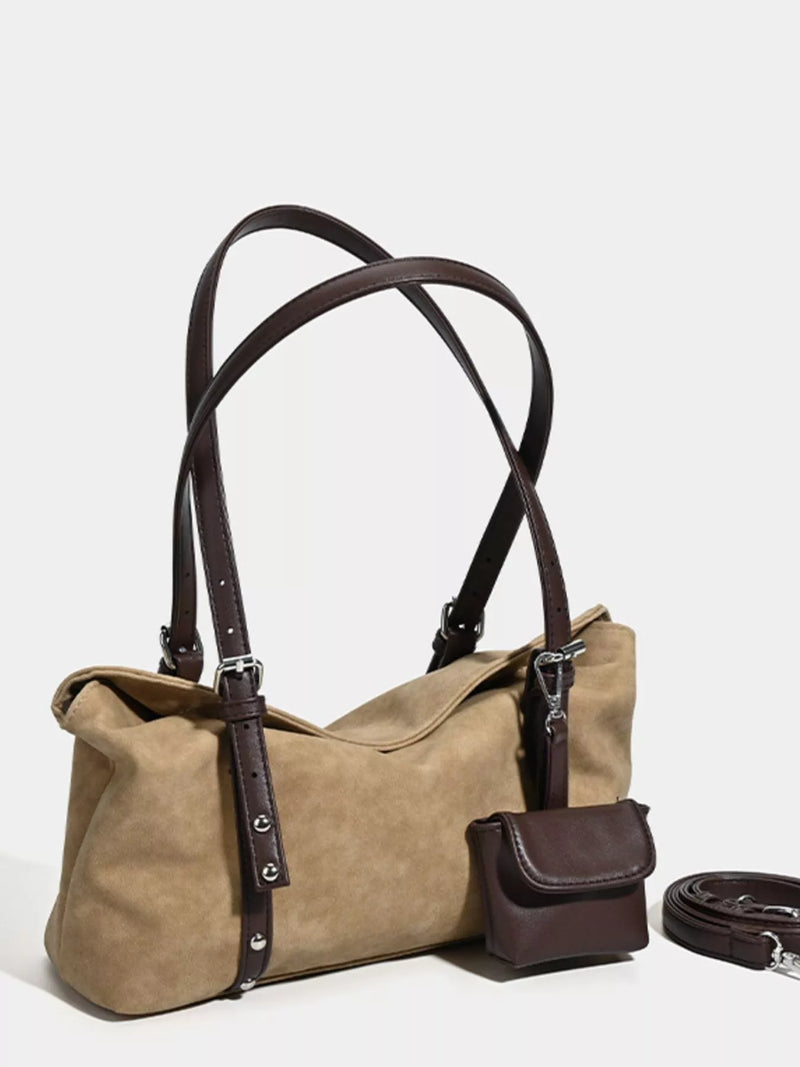 Brown leather handbag with matching pouch on a white background
