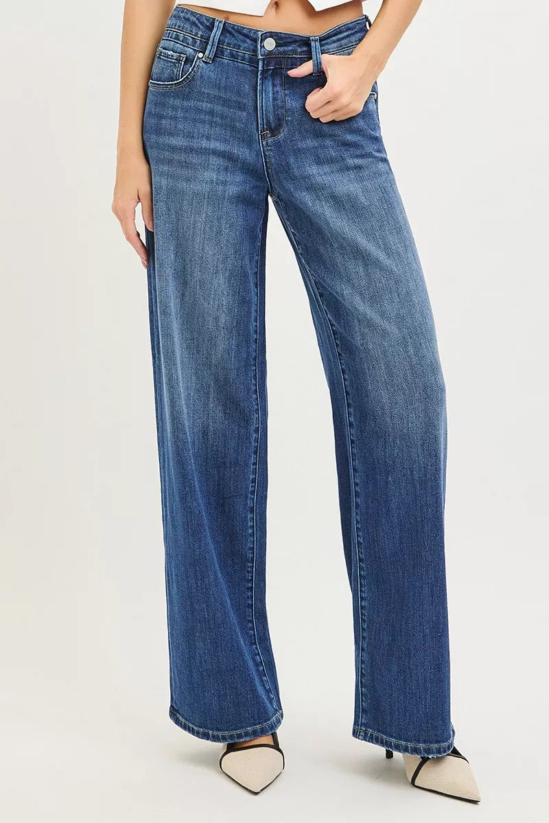 Person wearing blue jeans on a plain background