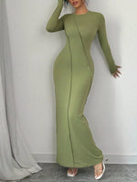 Green long-sleeve dress worn by a person against a gray background