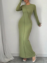 Green long-sleeve dress worn by a person against a gray background