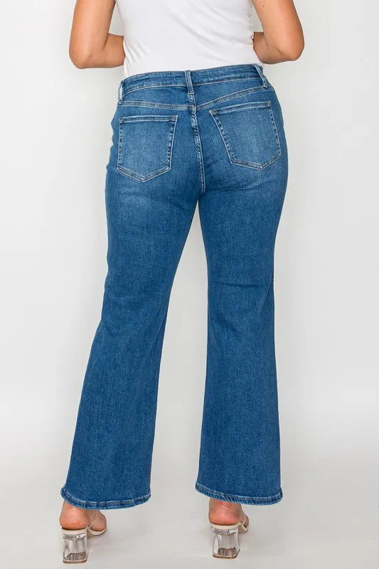 Person wearing blue jeans on a plain background