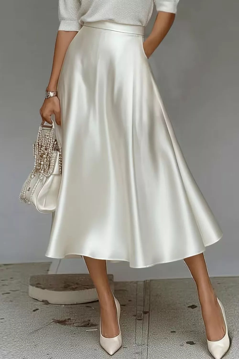 Woman wearing a white satin skirt with a plain background