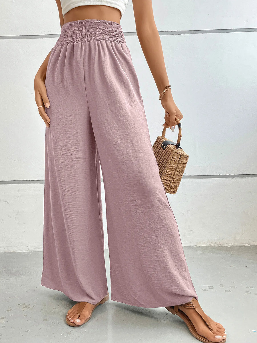 Person wearing pink wide-leg pants with a white background