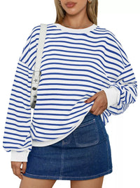 Person wearing a blue and white striped sweater with a denim skirt on a white background