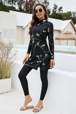 Woman wearing a black dress with gold floral patterns on white steps.