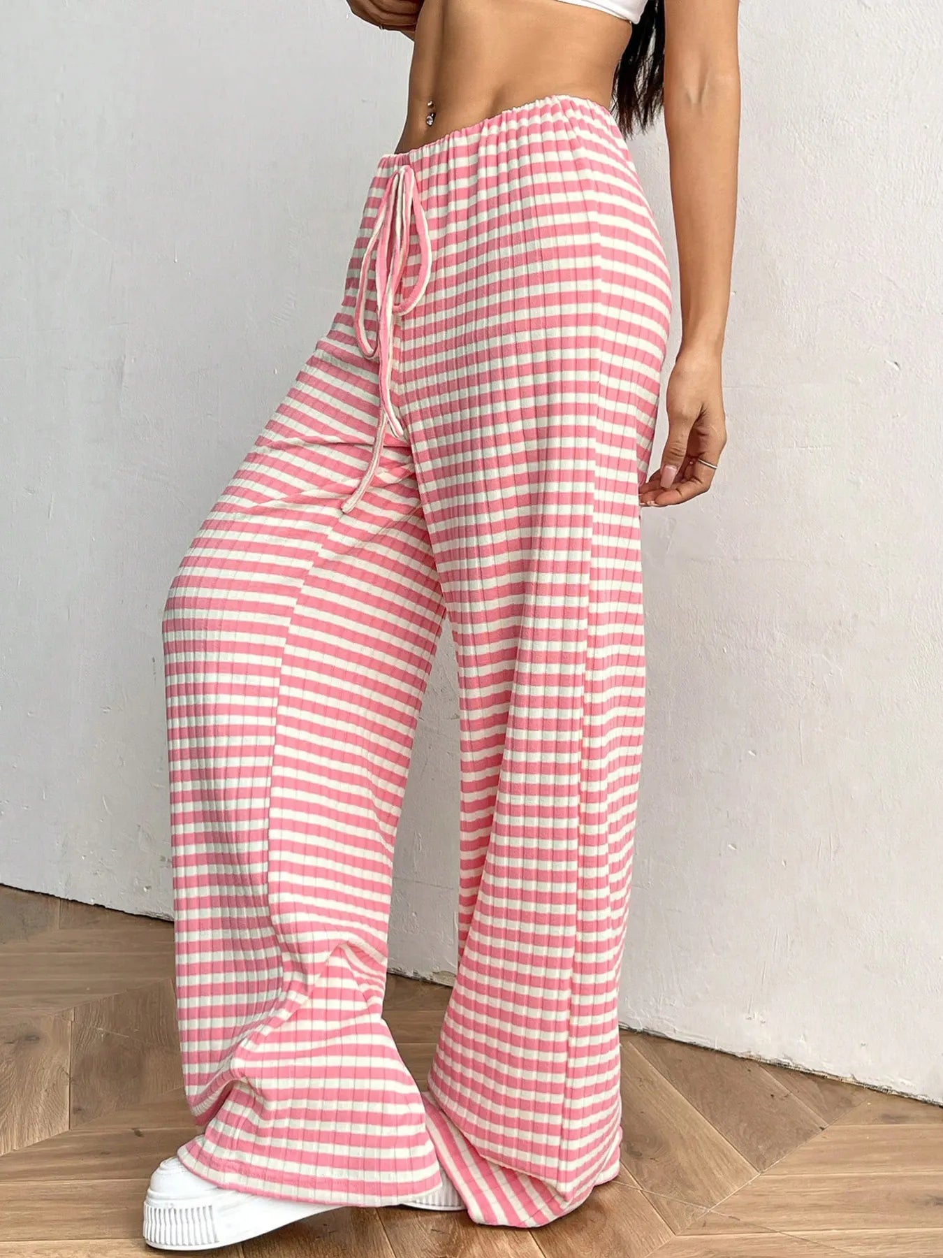 Person wearing pink and white checkered pants on a plain background