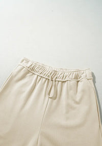 Beige pants with an elastic waistband on a light gray background